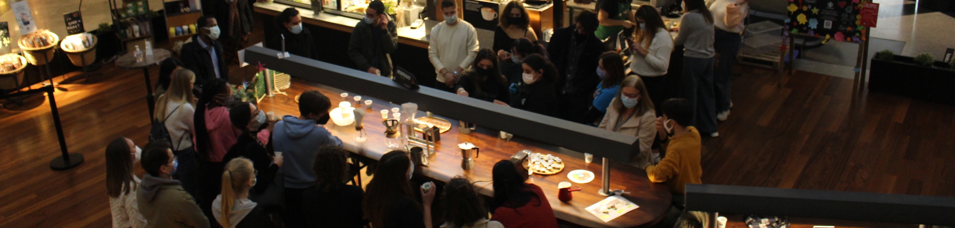 Multiple people around a coffee workshop table in a coffee shop