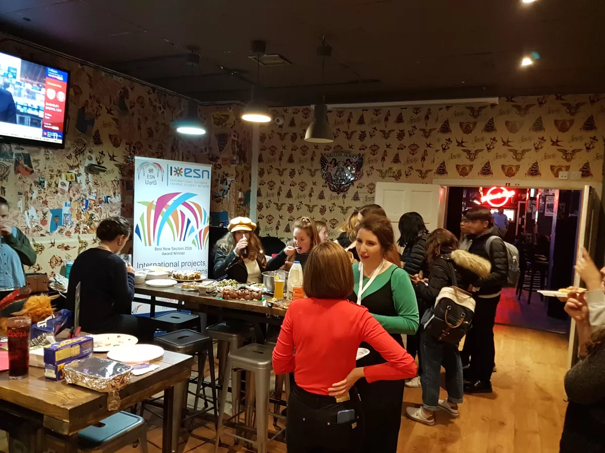 Image displays students enjoying some food together in a bar.