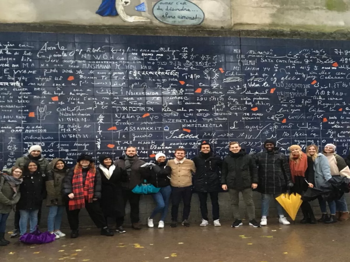 Group of people in front of the Je t'aime wall.