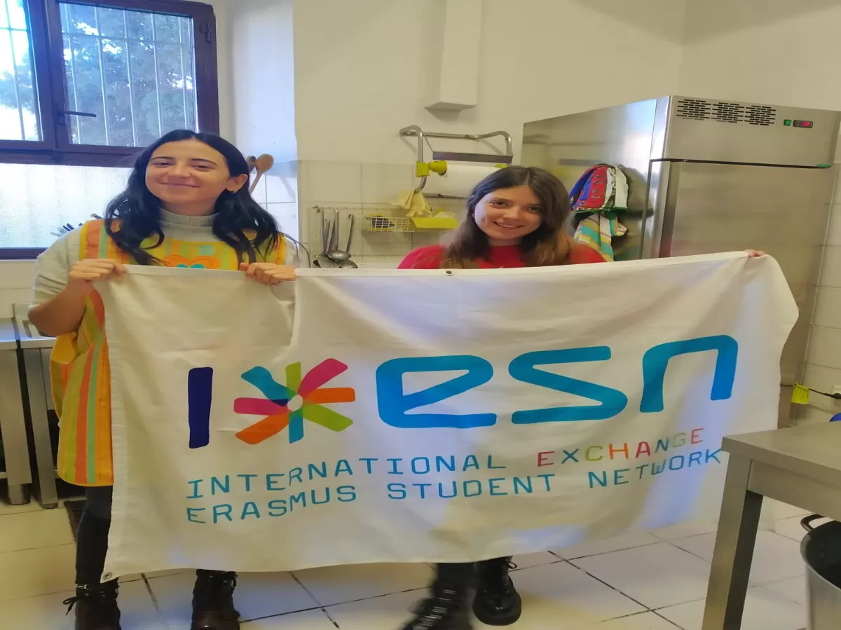 Two international students holding ESN flag after the service in the soup kitchen