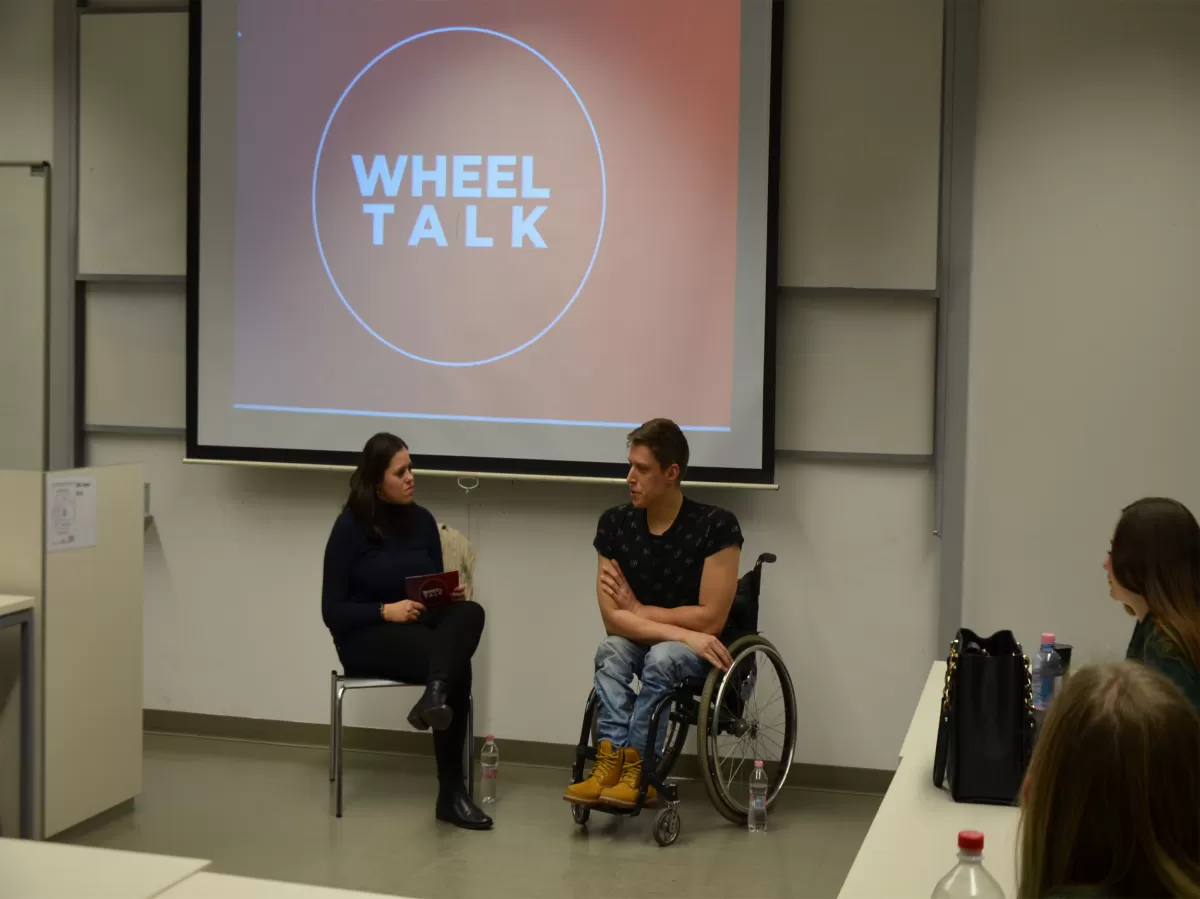 Zoli, our guest in a wheelchair is talking with the moderator.