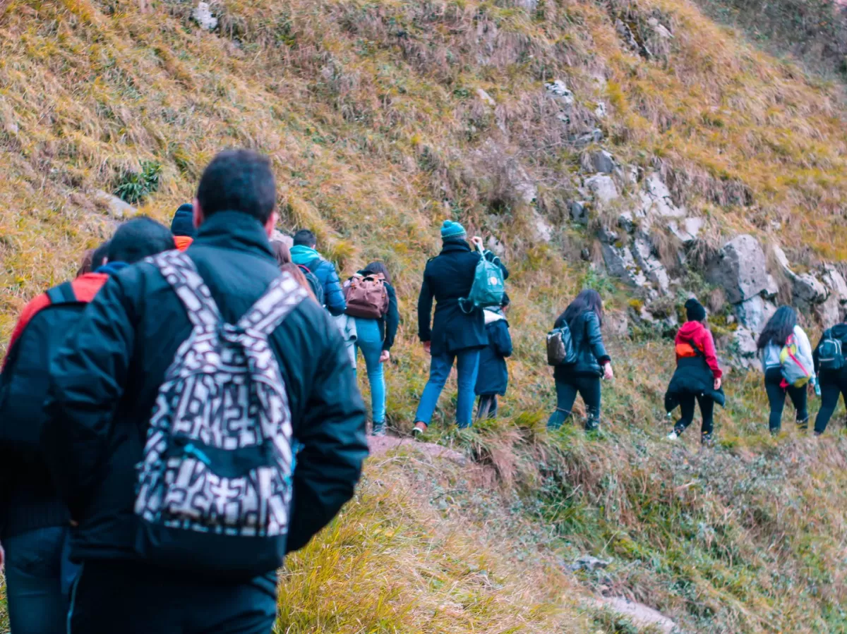 A line of people hiking along a mountanous path