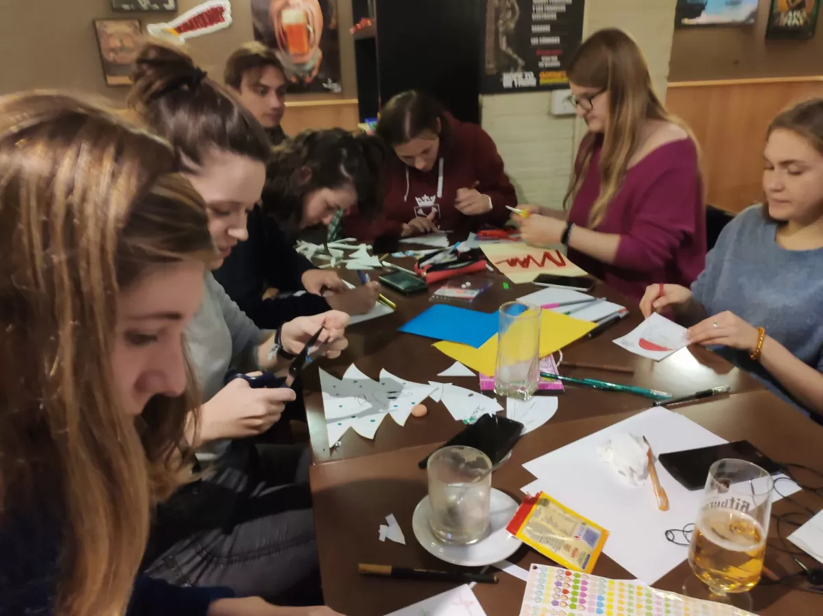 Several people making postcars at a table