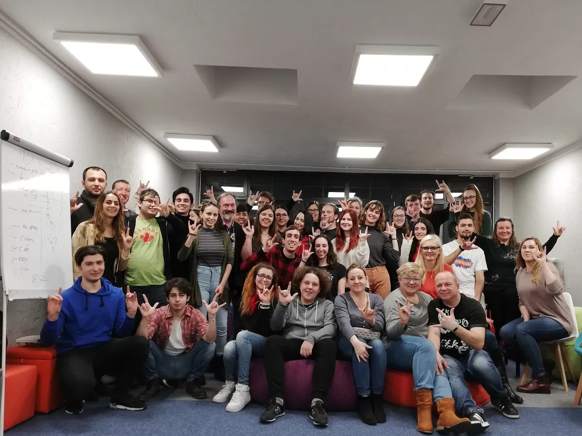 Group of international students and polish people showing international sign for "I love you"