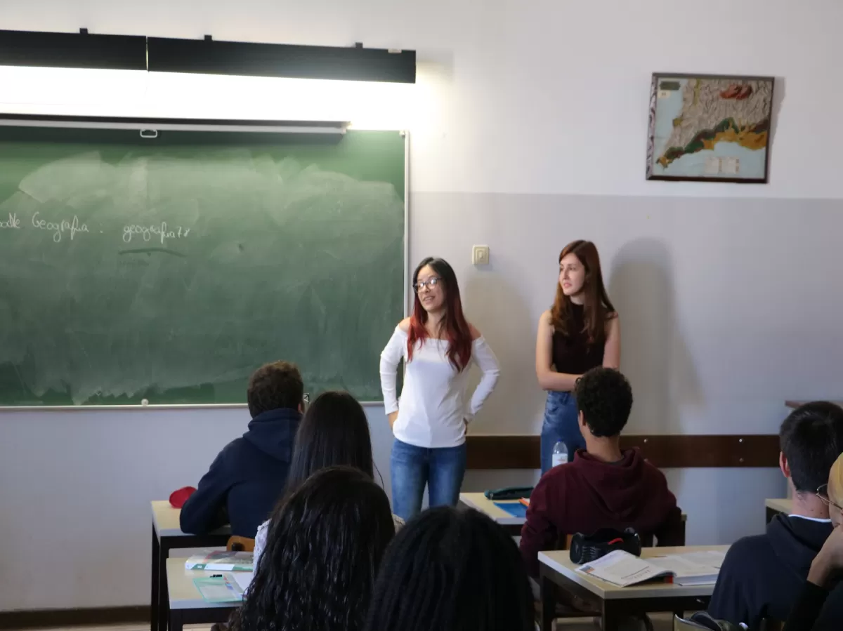 Two international students volunteering in a classroom.