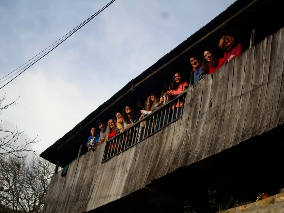 Several students lean over a wooden structure