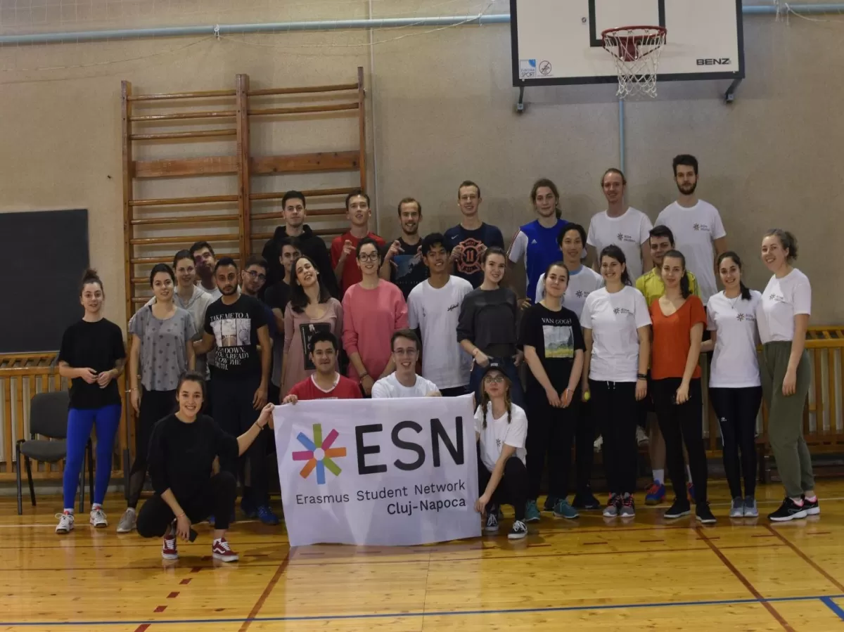 Group of international students and ESN volunteers holding the ESN Cluj-Napoca flag