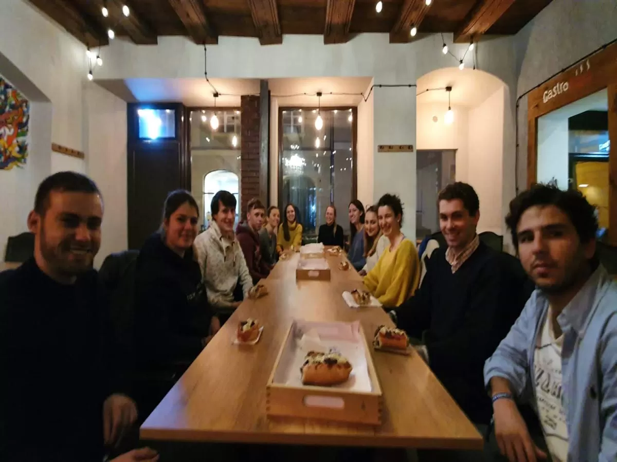 A group of international students sitting at a long table in a restaurant