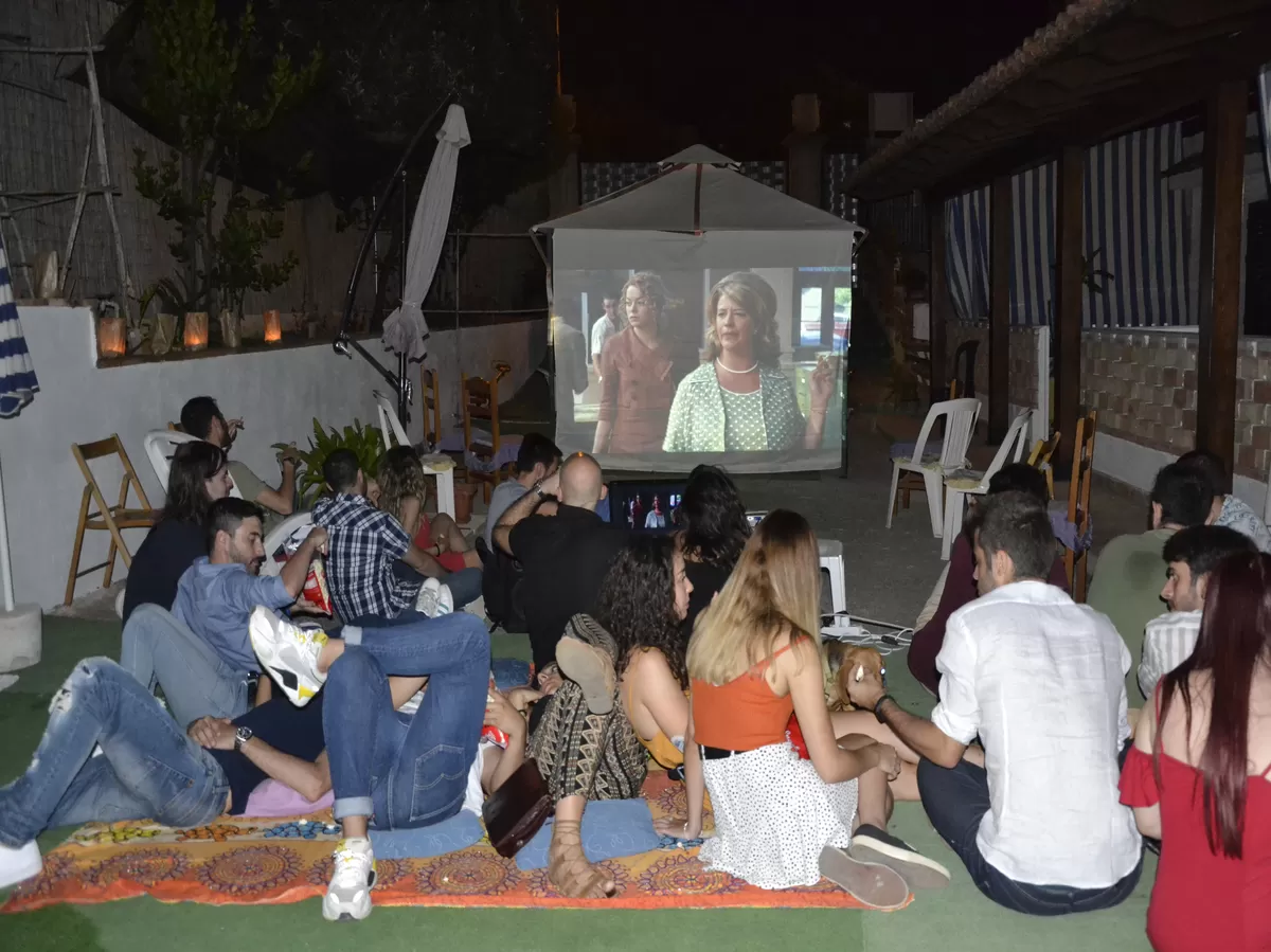 Participants sitting on the lawn watching the film. 