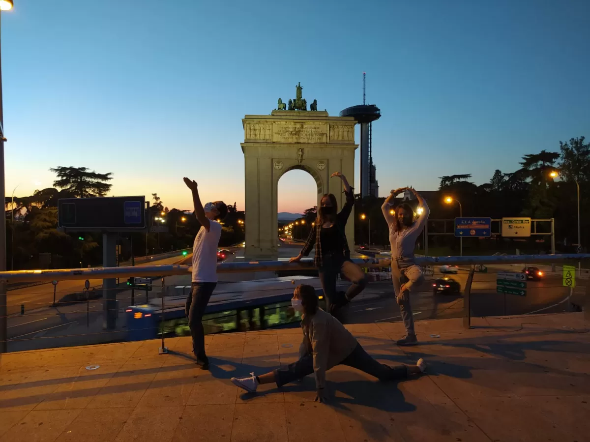 International students posing with the Arco de la Victoria at dawn.