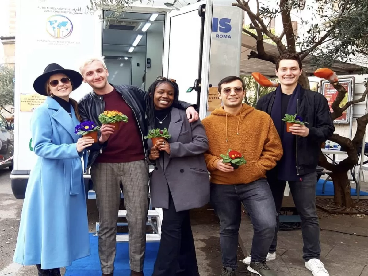 Volunteers and Erasmus students standing in front of the blood donation truck