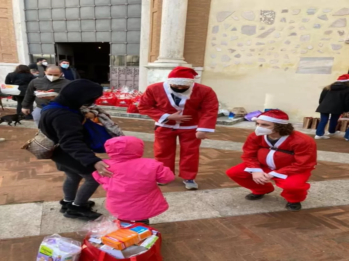 Two guys dressed up as Santa to give the donations to the families