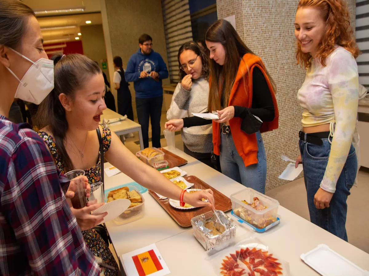 International students trying food at the Spanish stand