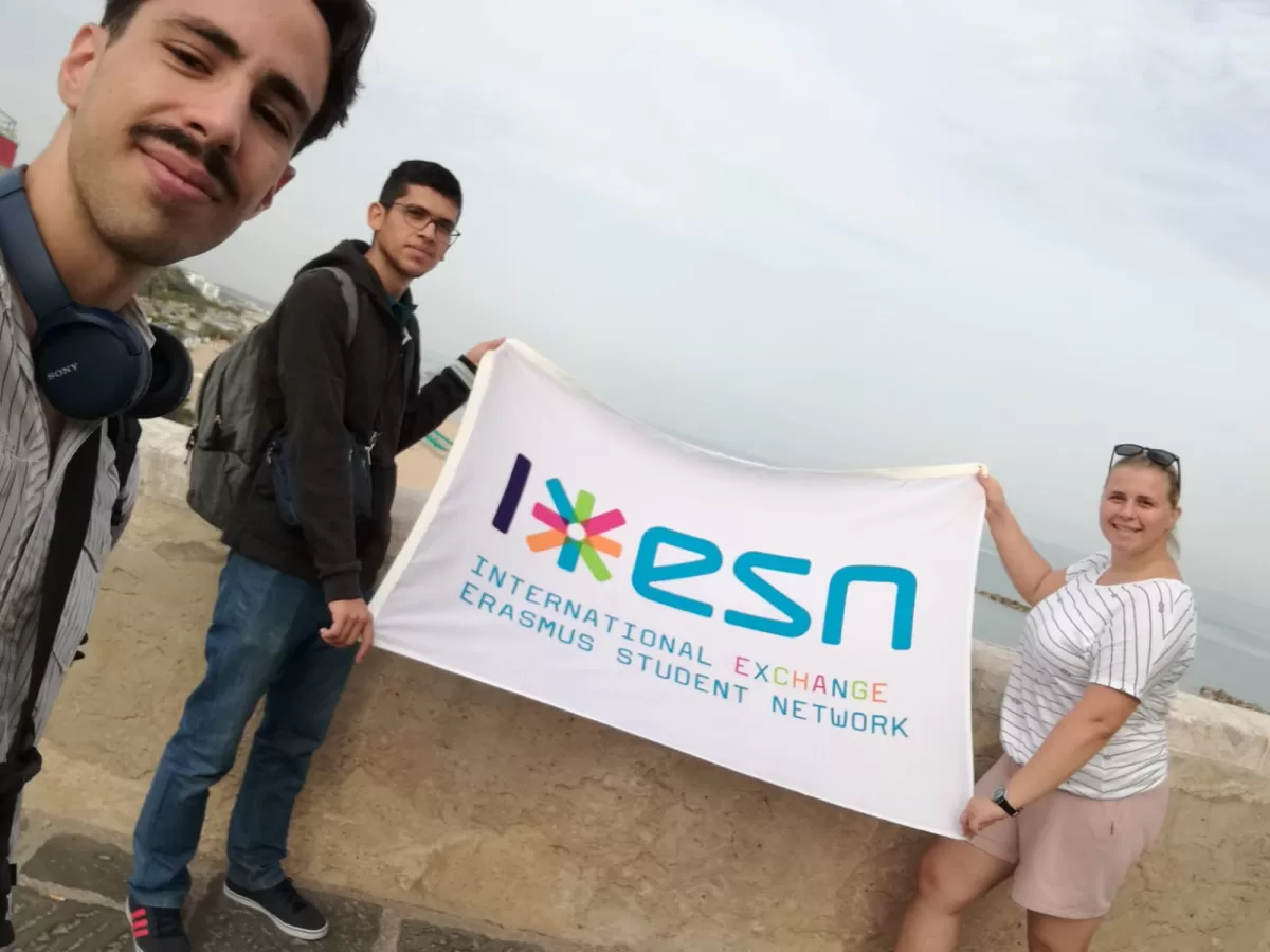 Three people posing with an ESN flag
