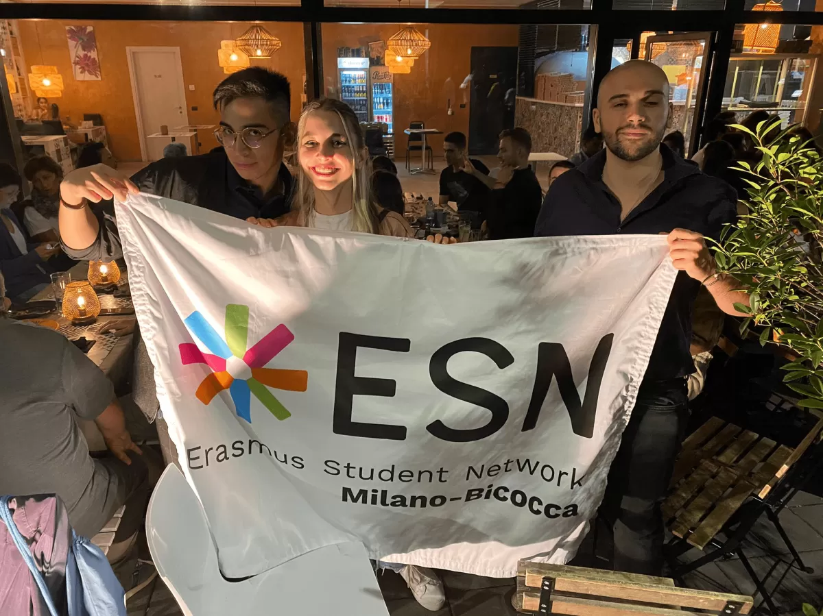 erasmus students posing with the ESN Milano-Bicocca flag 