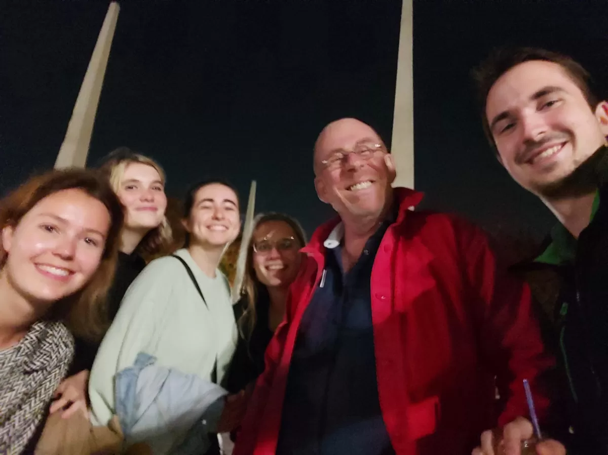 A team of international students taking a selfie with a stranger as part of a challange