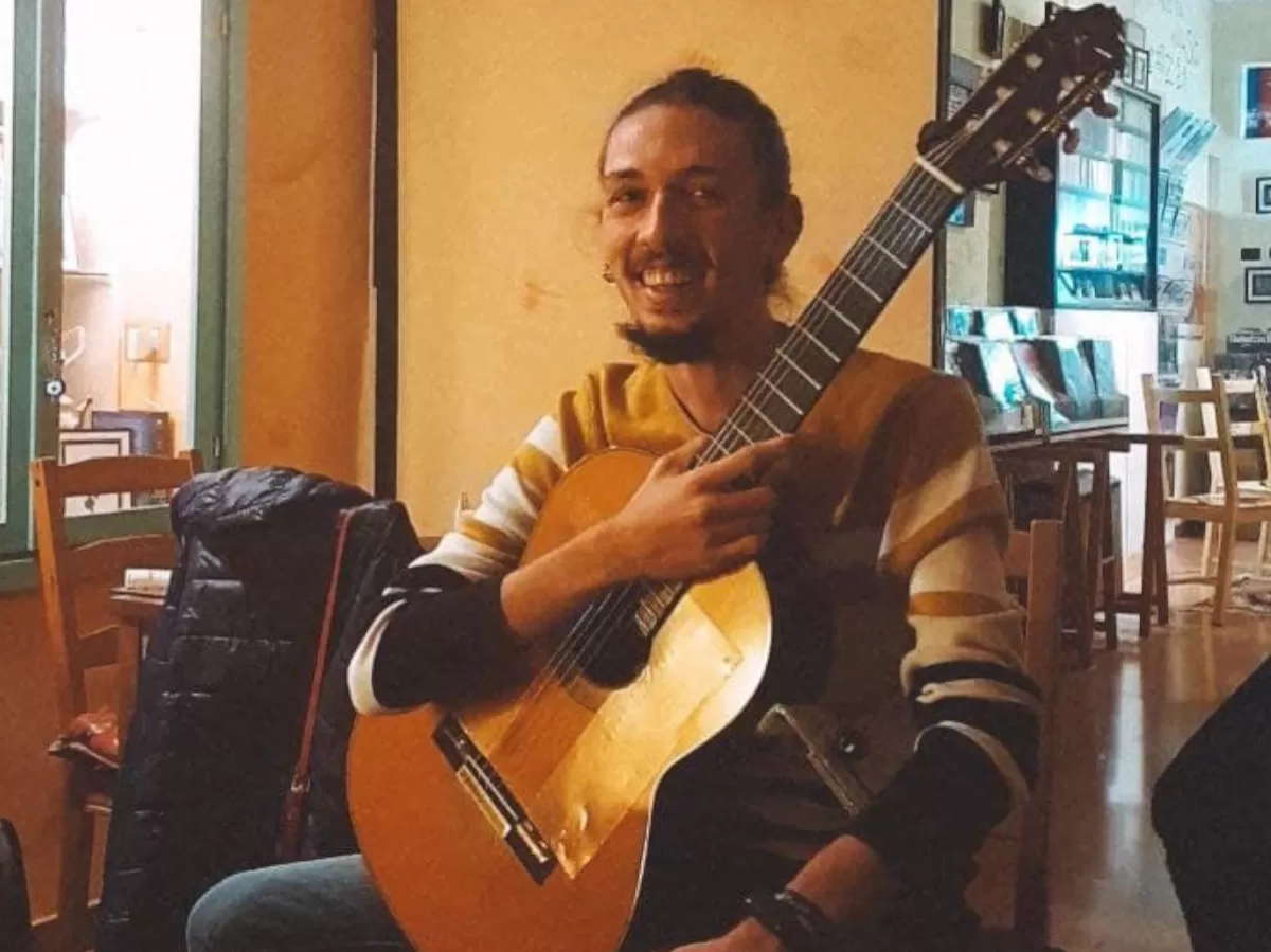a turkish guy posing with is guitar