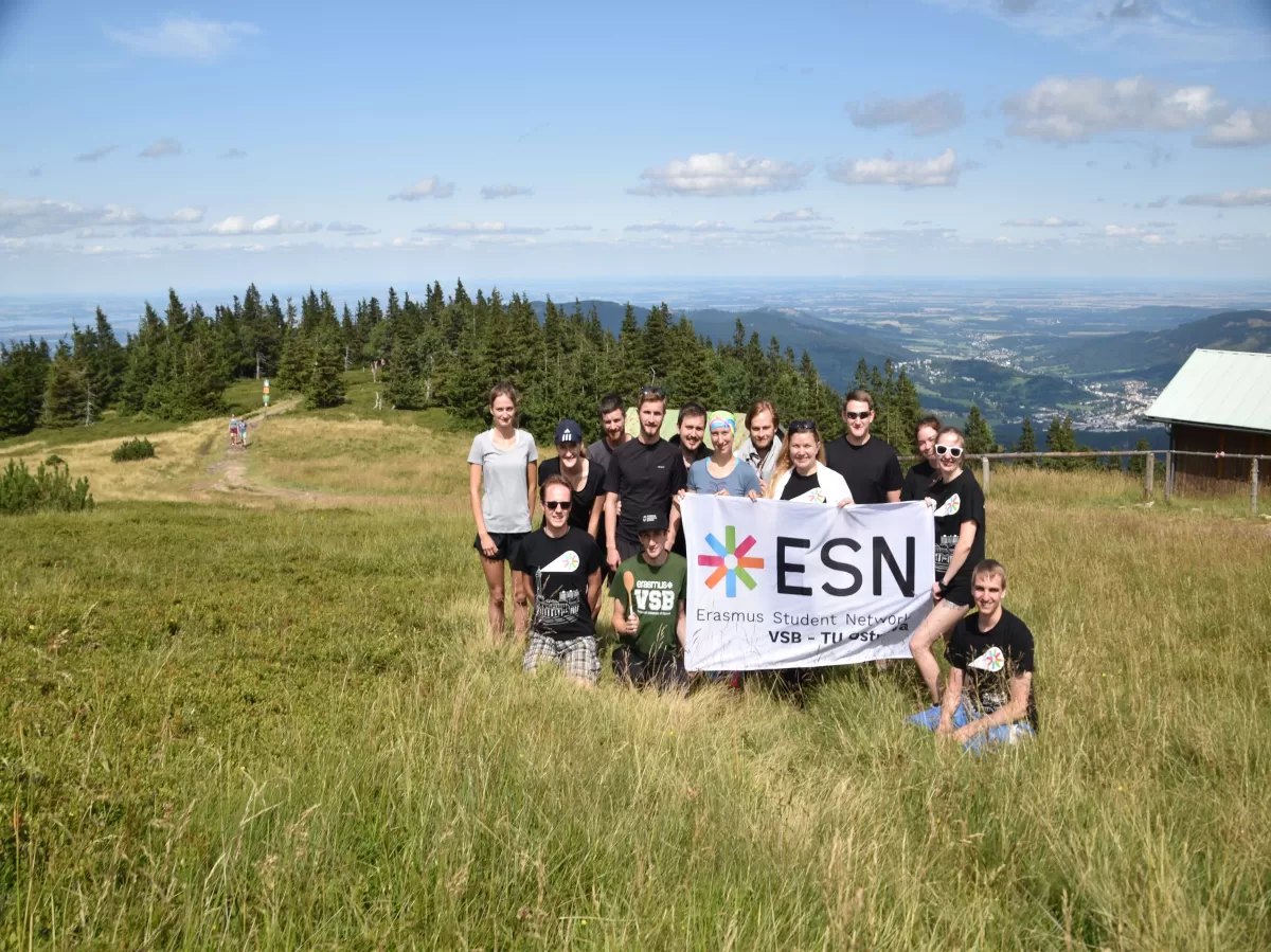 ESNers holding ESN flag at the top of th mountain