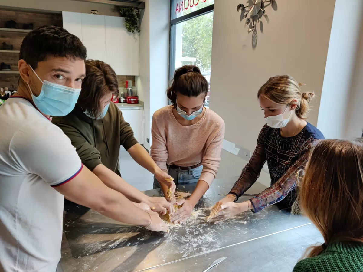Group of international students cooking homemade pasta
