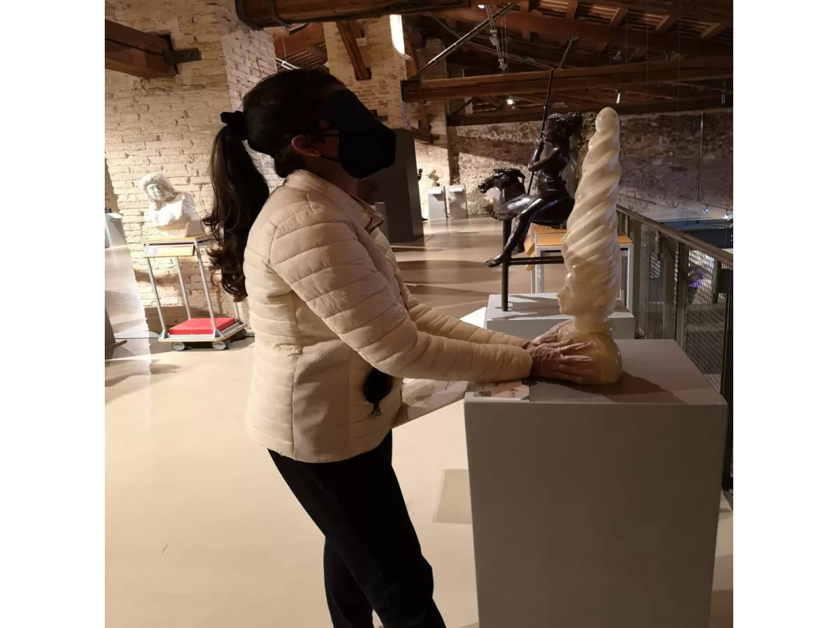 An international student touching a statue while blindfolded
