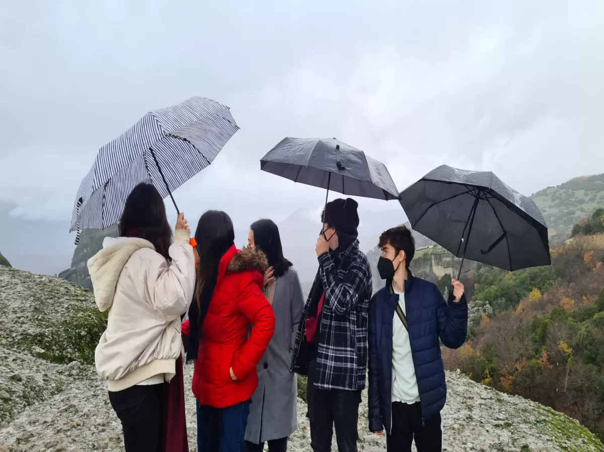 Group of students in Meteora holding their umbrellas