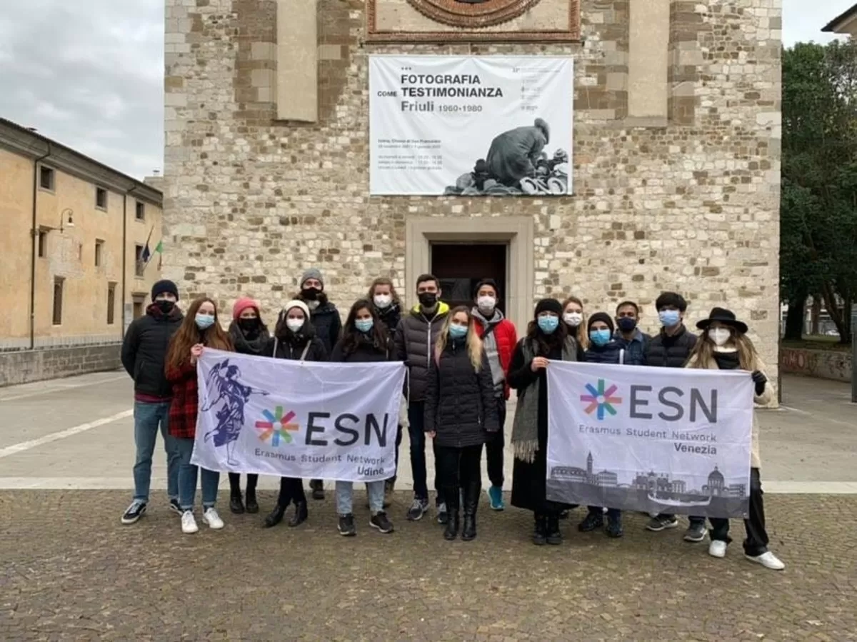 Group of Students with the volunteers of ESN Udine holding the two flags of the sections