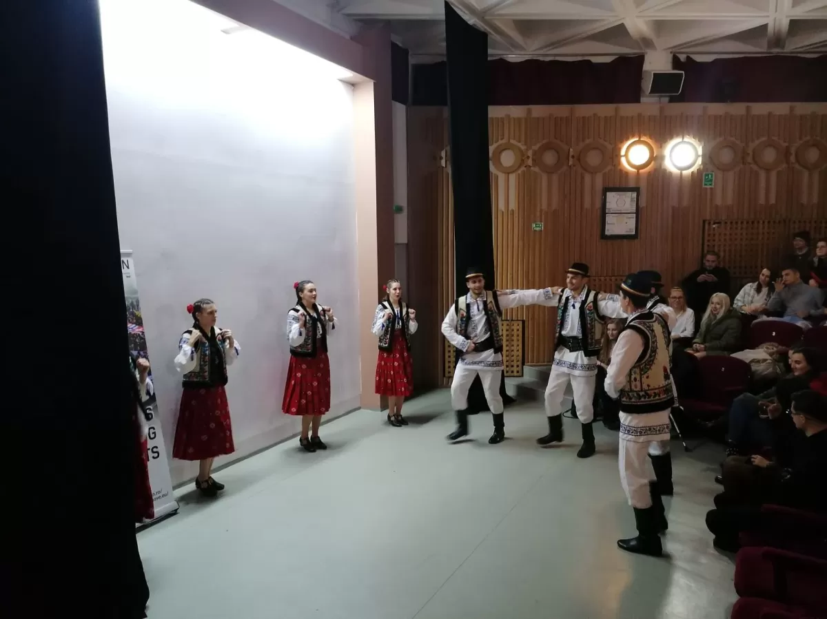 8 people dancing the traditional Romanian dance "hora"
