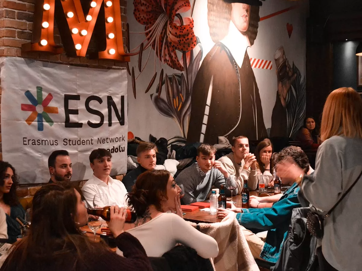 President of ESN Anadolu is giving a speech to participants and participants around a long table are listening to her.