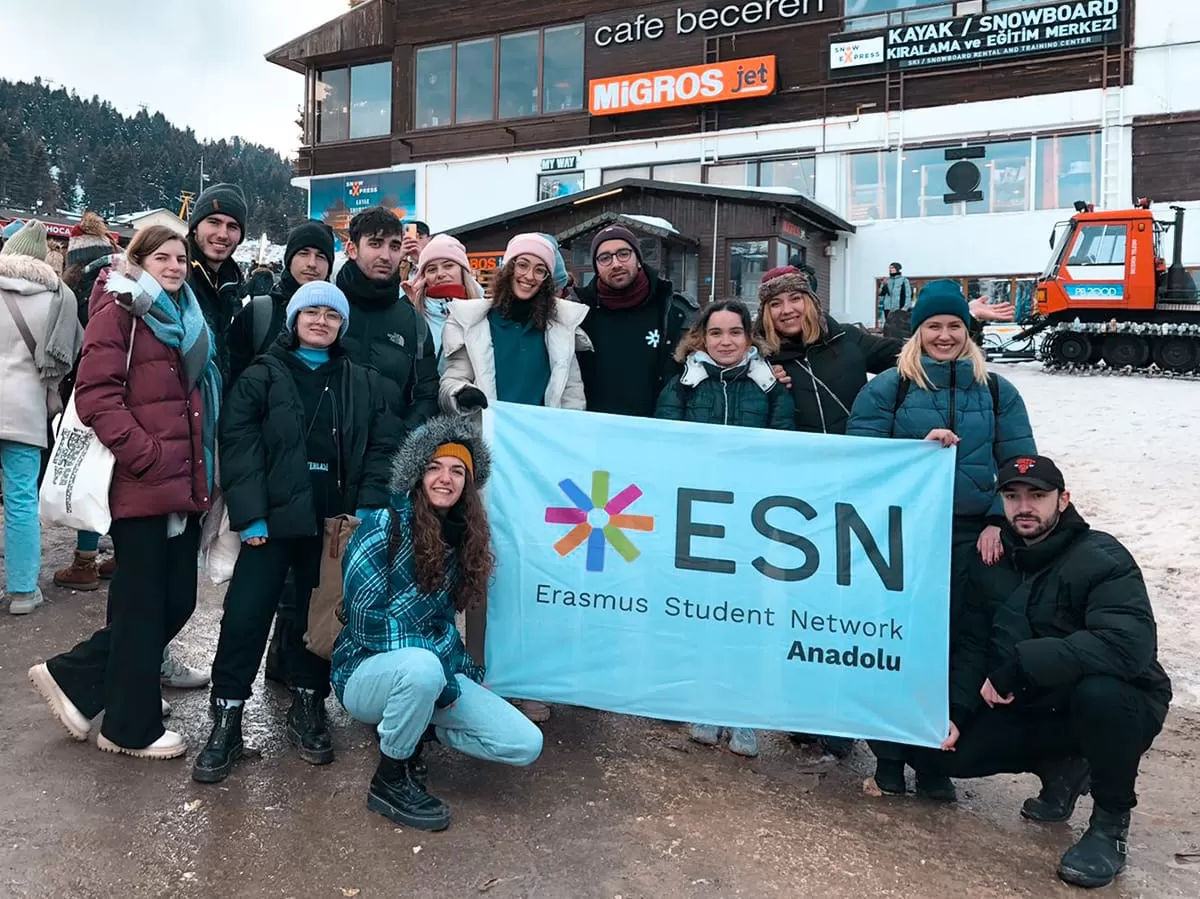 Participants smiling at the camera and holding the flag of ESN Anadolu 