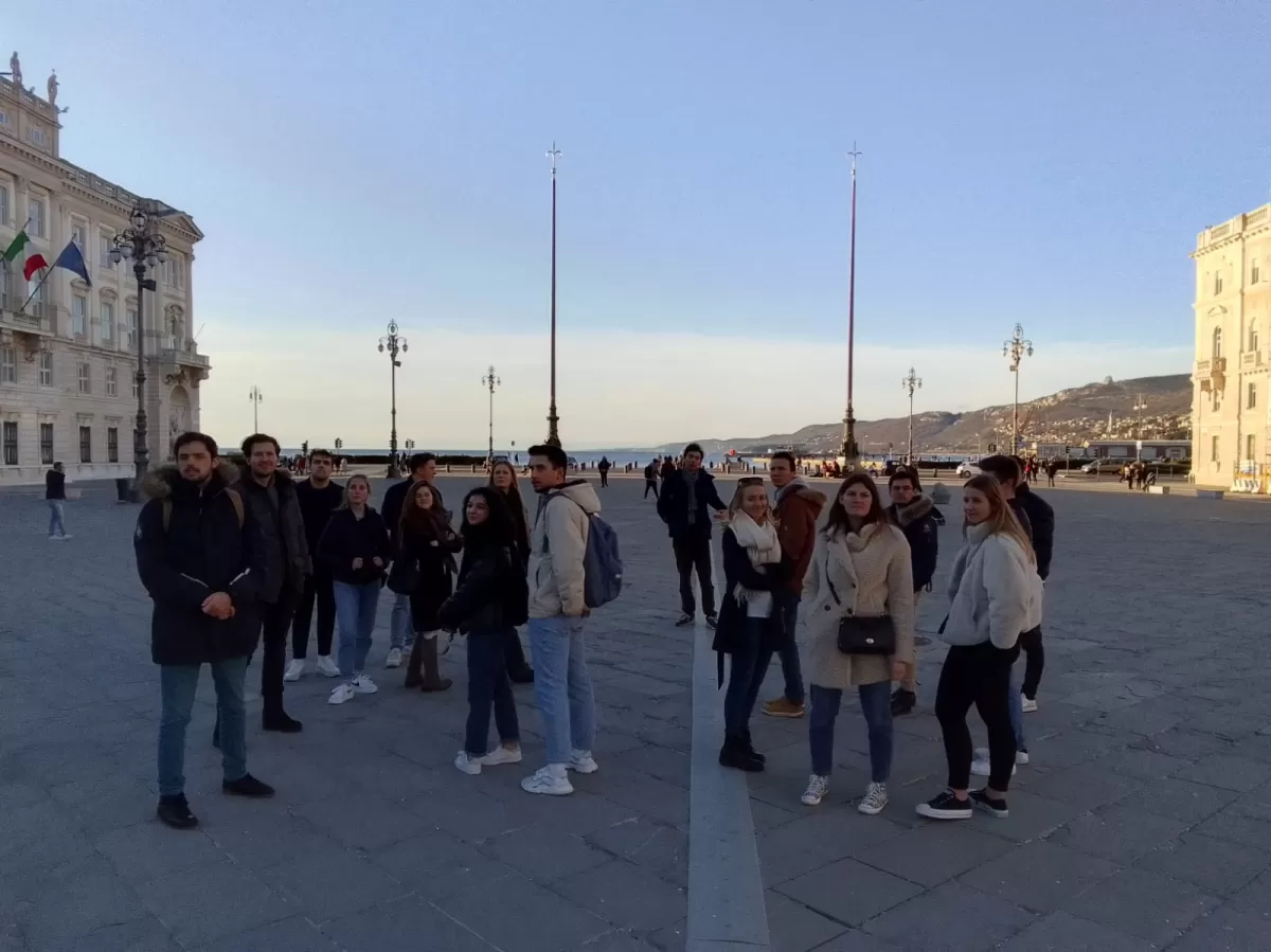 Group picture of incoming students and guide on the main square of Trieste