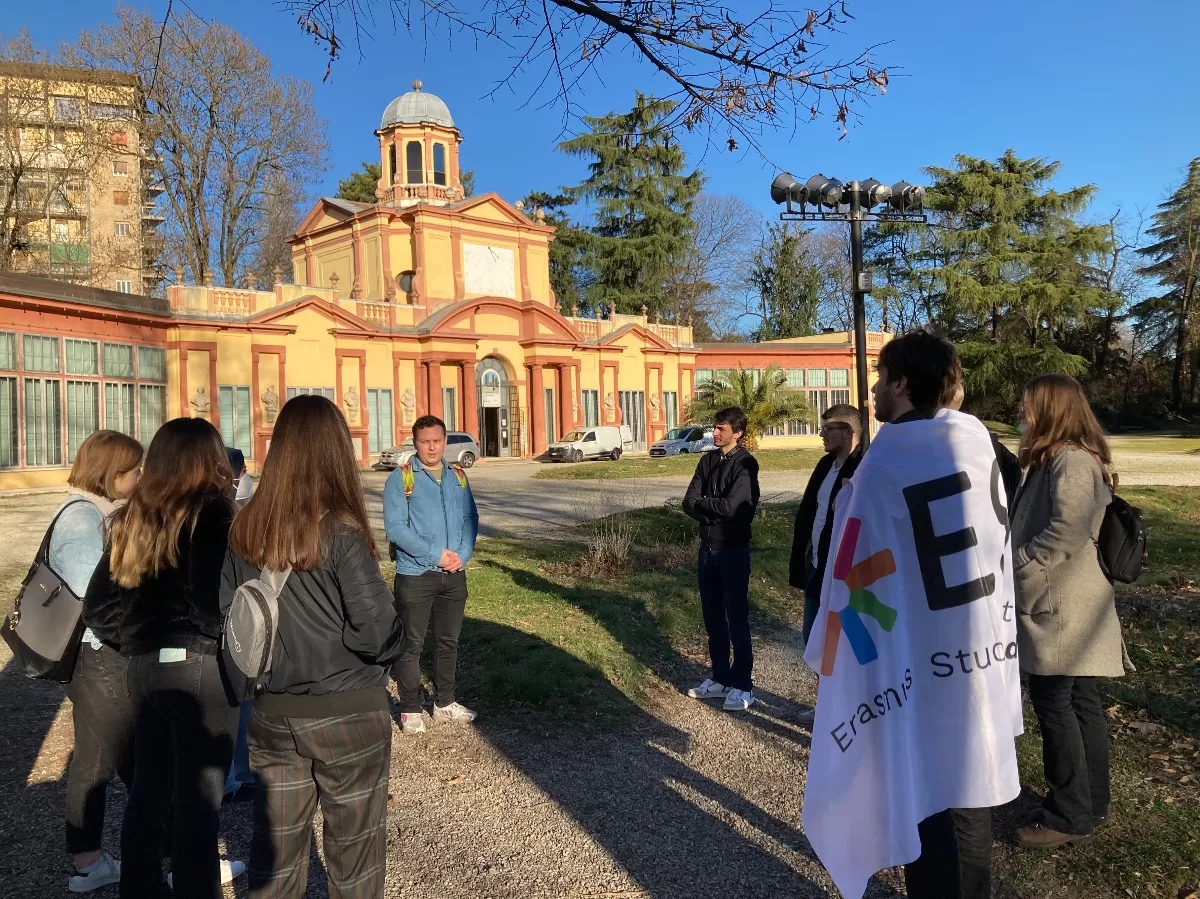 a group of students listening to a guide in front of the Palazzina in Paro Giardini Ducali Estense