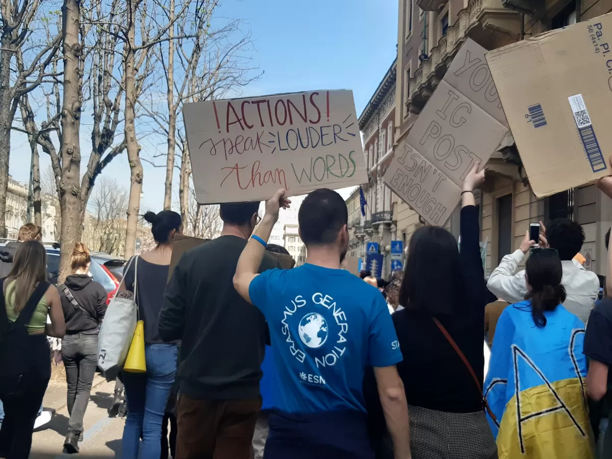 A volunteer with the Erasmus generation t-shirt is showing his poster