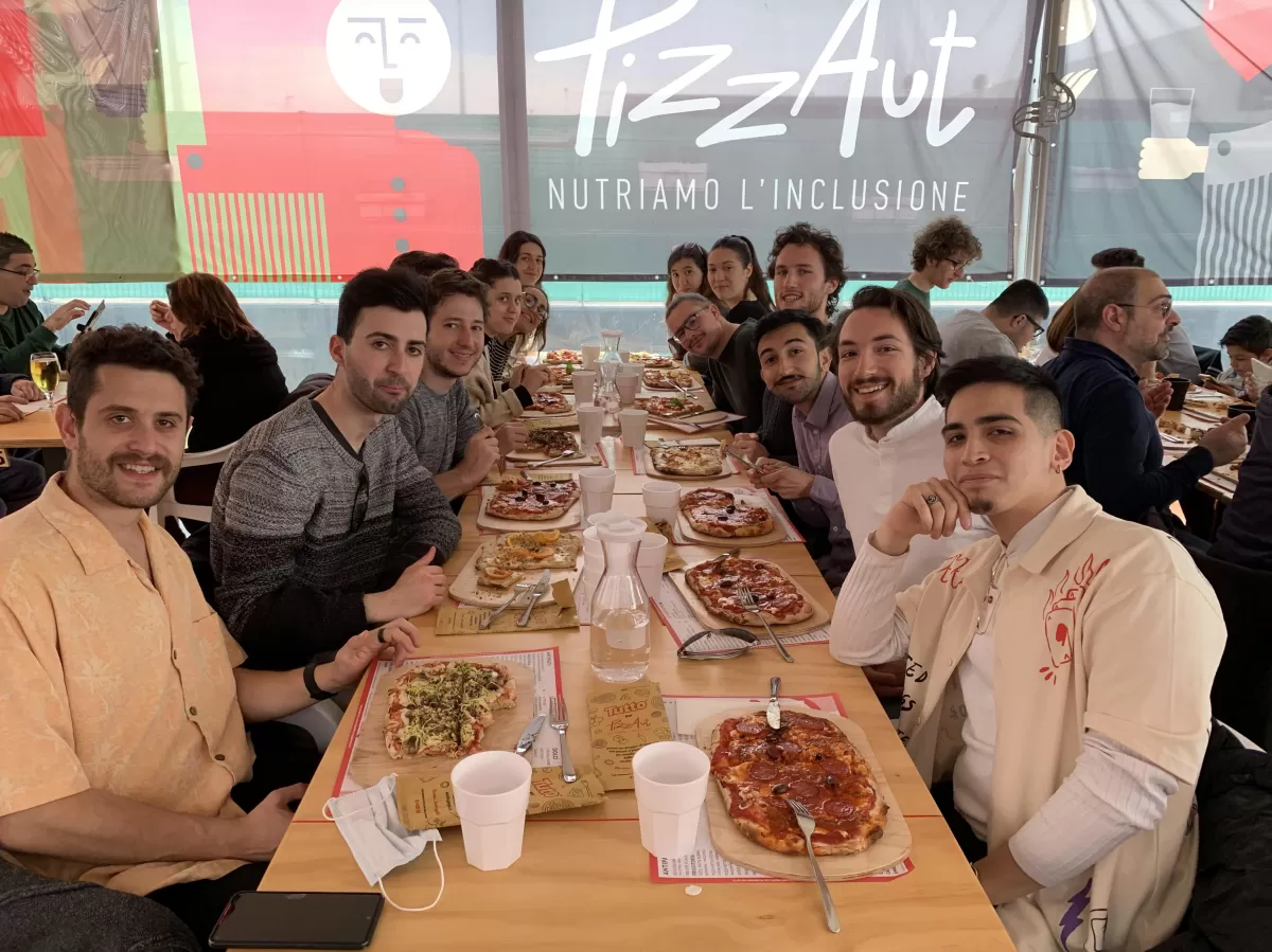 Group of international students enjoying their meal eating pizza