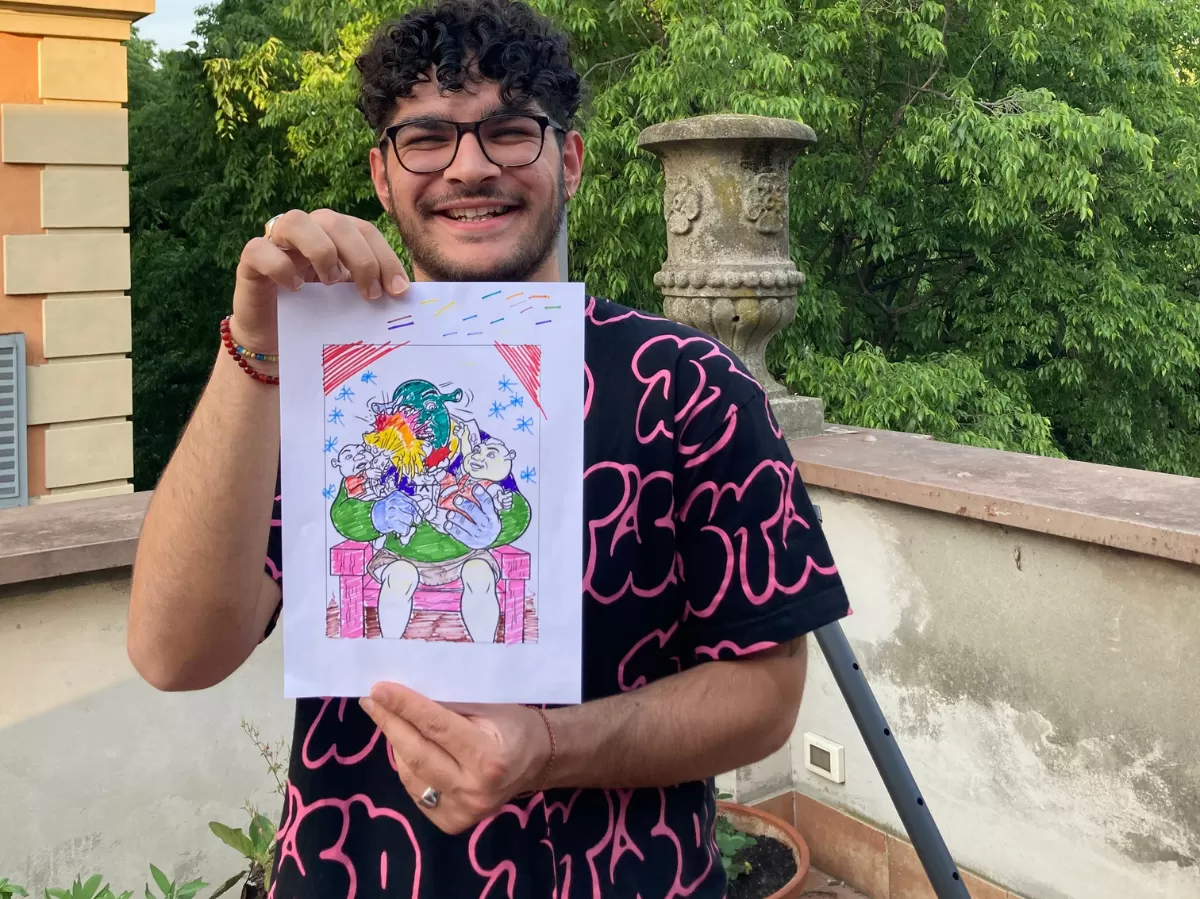 International student holding his winning drawing