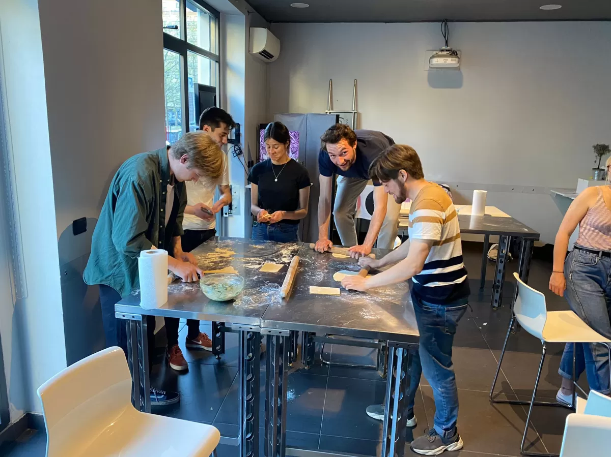 Group of international students preparing homemade pasta around the table