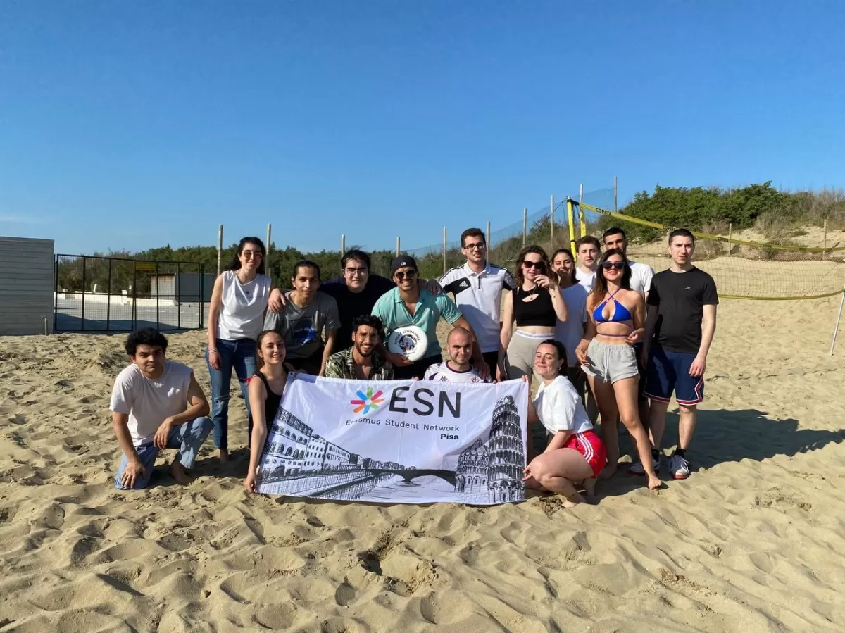 Erasmus students at Tirrenia beach with ESN Pisa flag