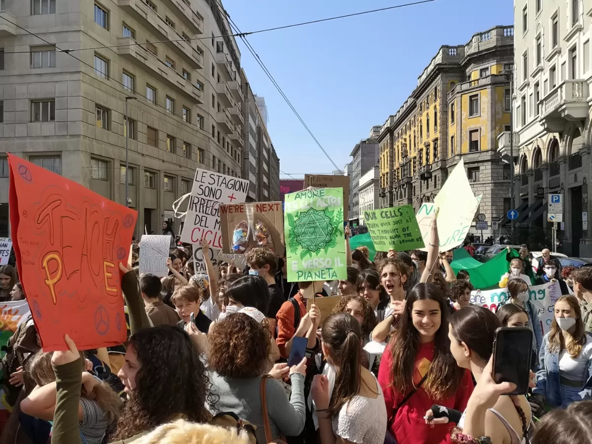 Group of international students walking in the street with climate signs