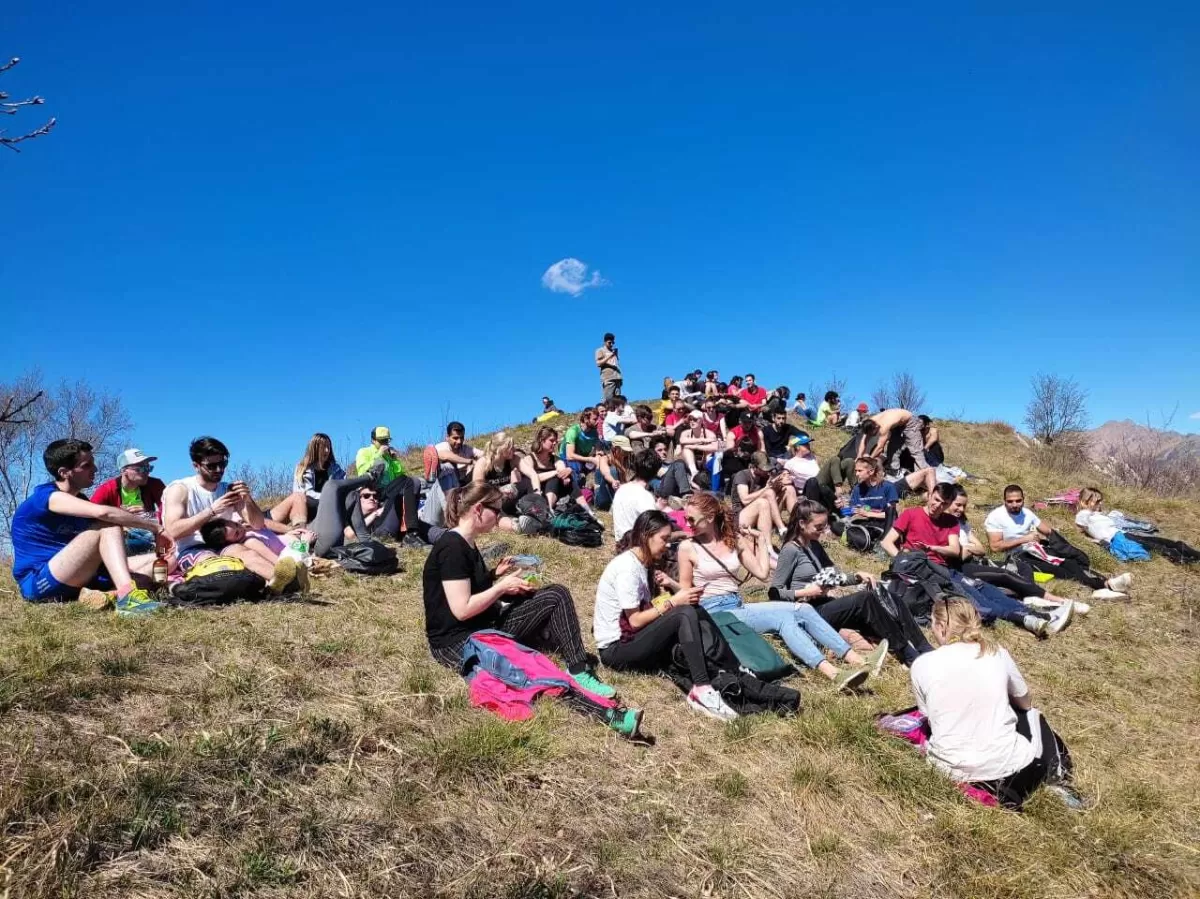 Group of international students resting on top of the mountain after the hiking