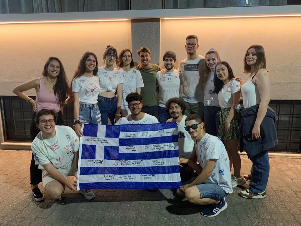 group photo of the team with their new painted white t-shirts and a painted greek flag