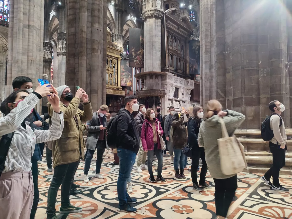 Group of international students taking pictures and looking the interior of Duomo cathedral