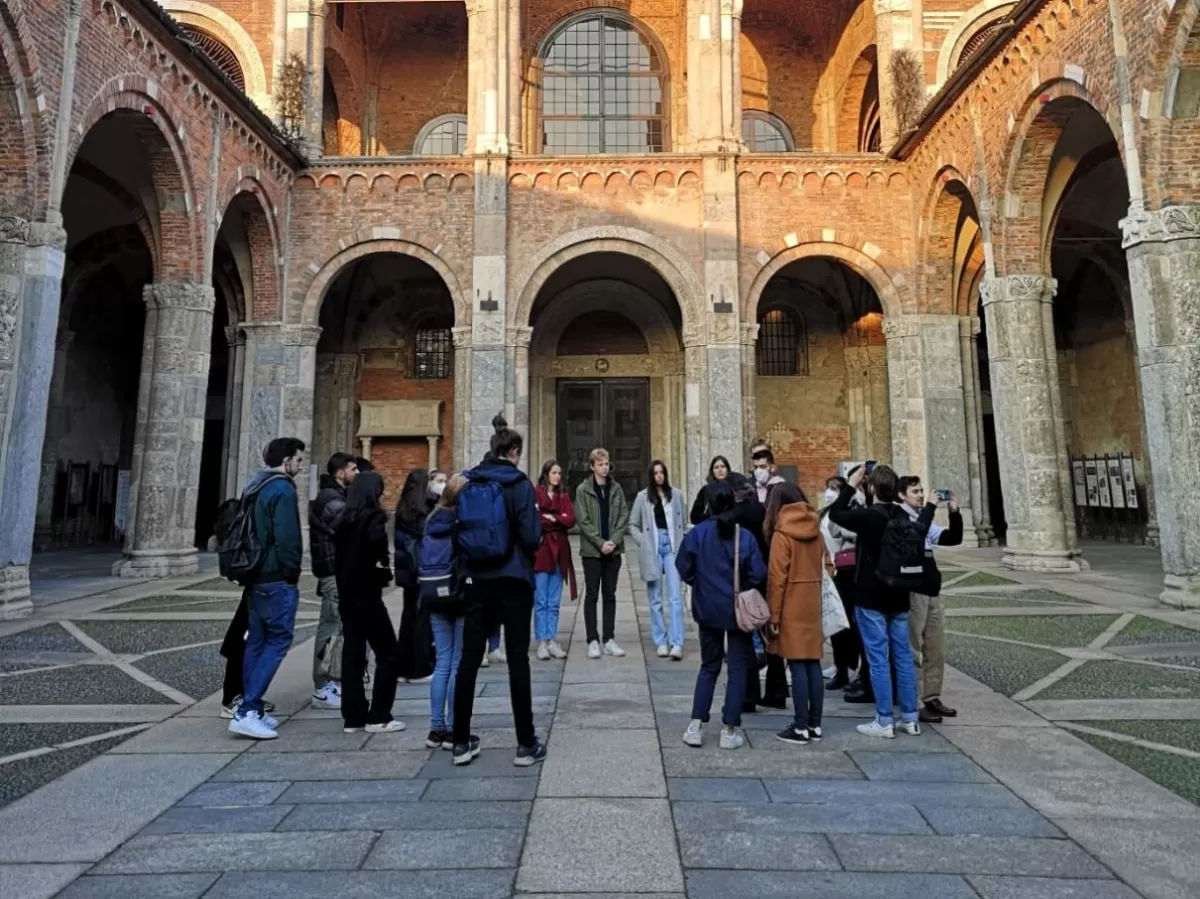 Group of international students standing in the cloister of Sant'Ambrogio church