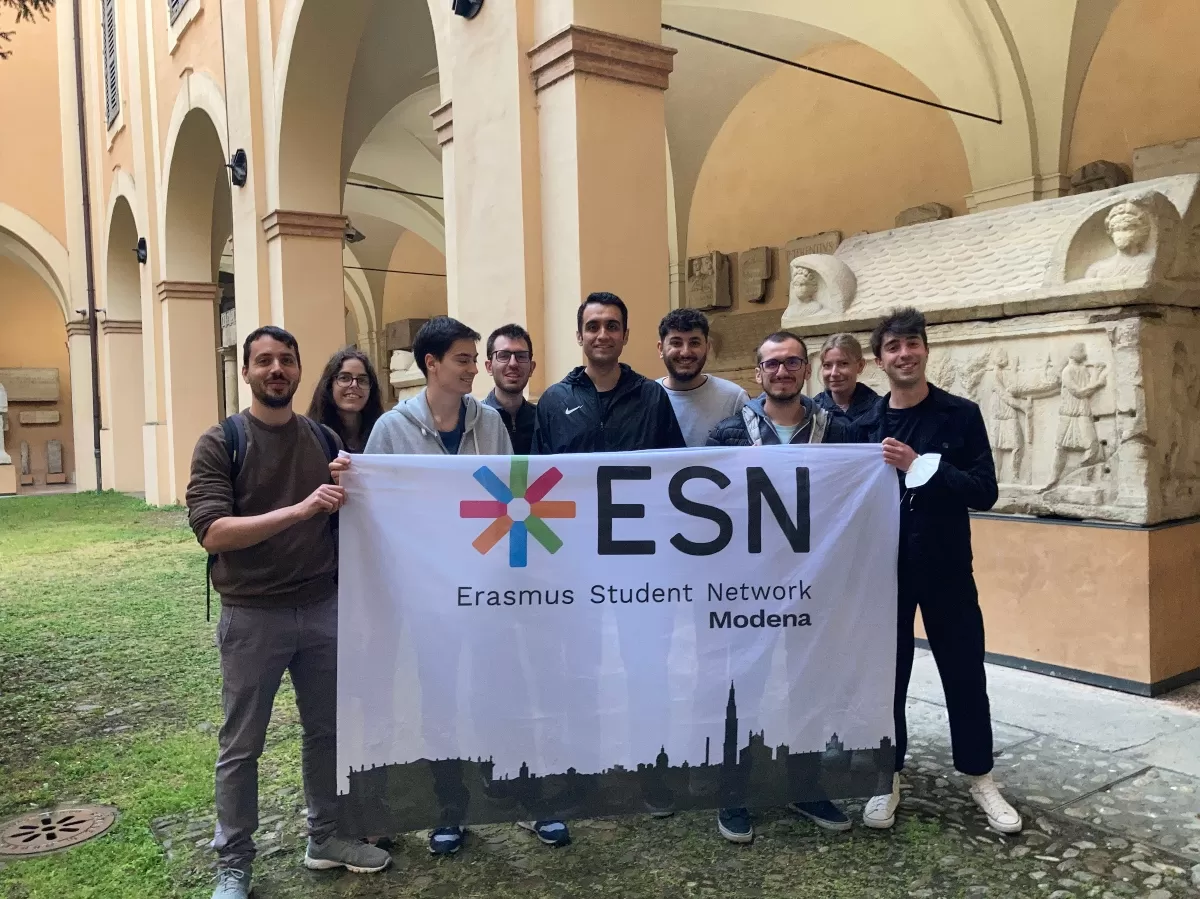students posing with the ESN Modena flag in the Palazzo dei Musei inner courtyard