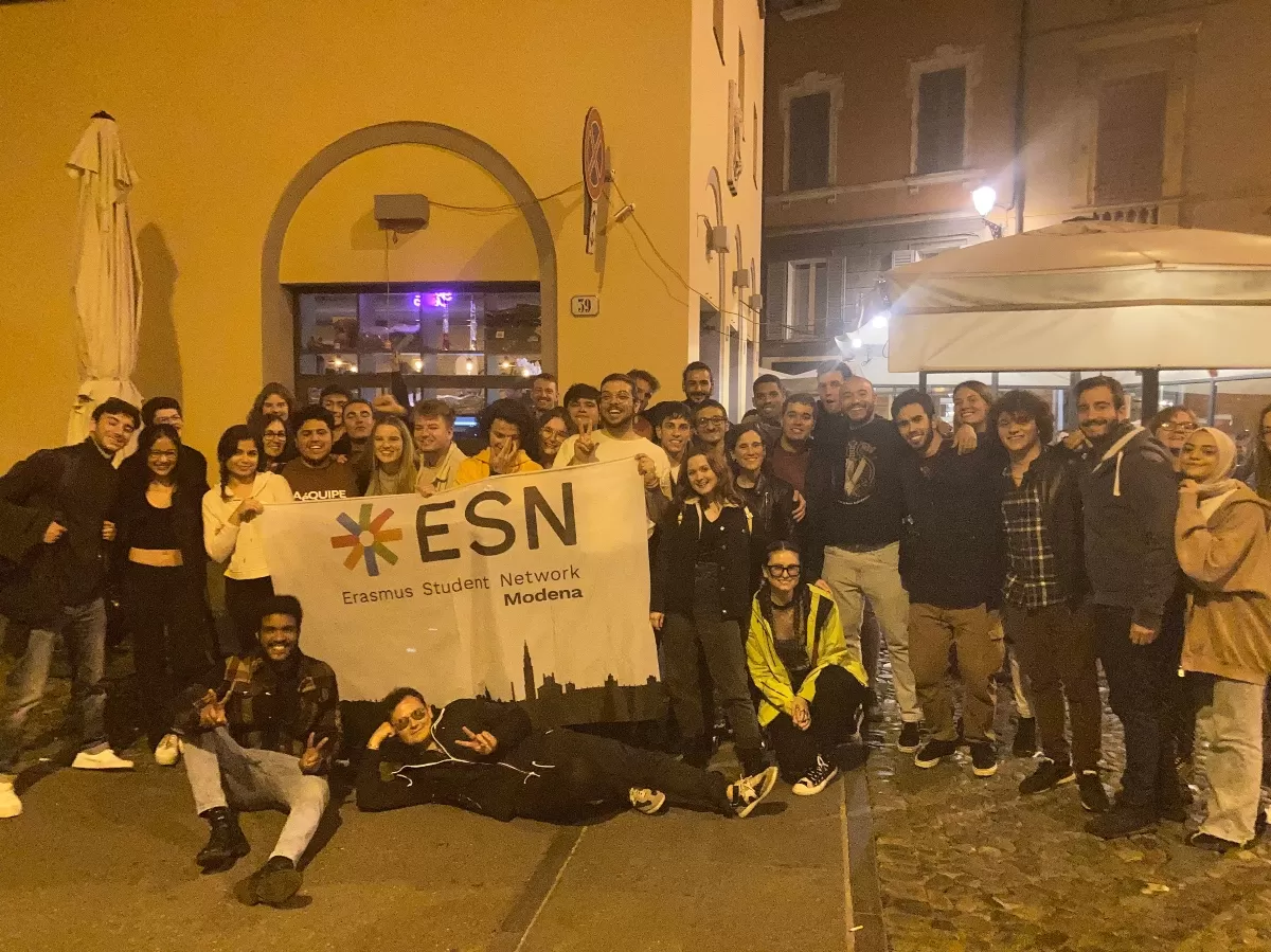 group of international students posing with the flag of ESN Modena