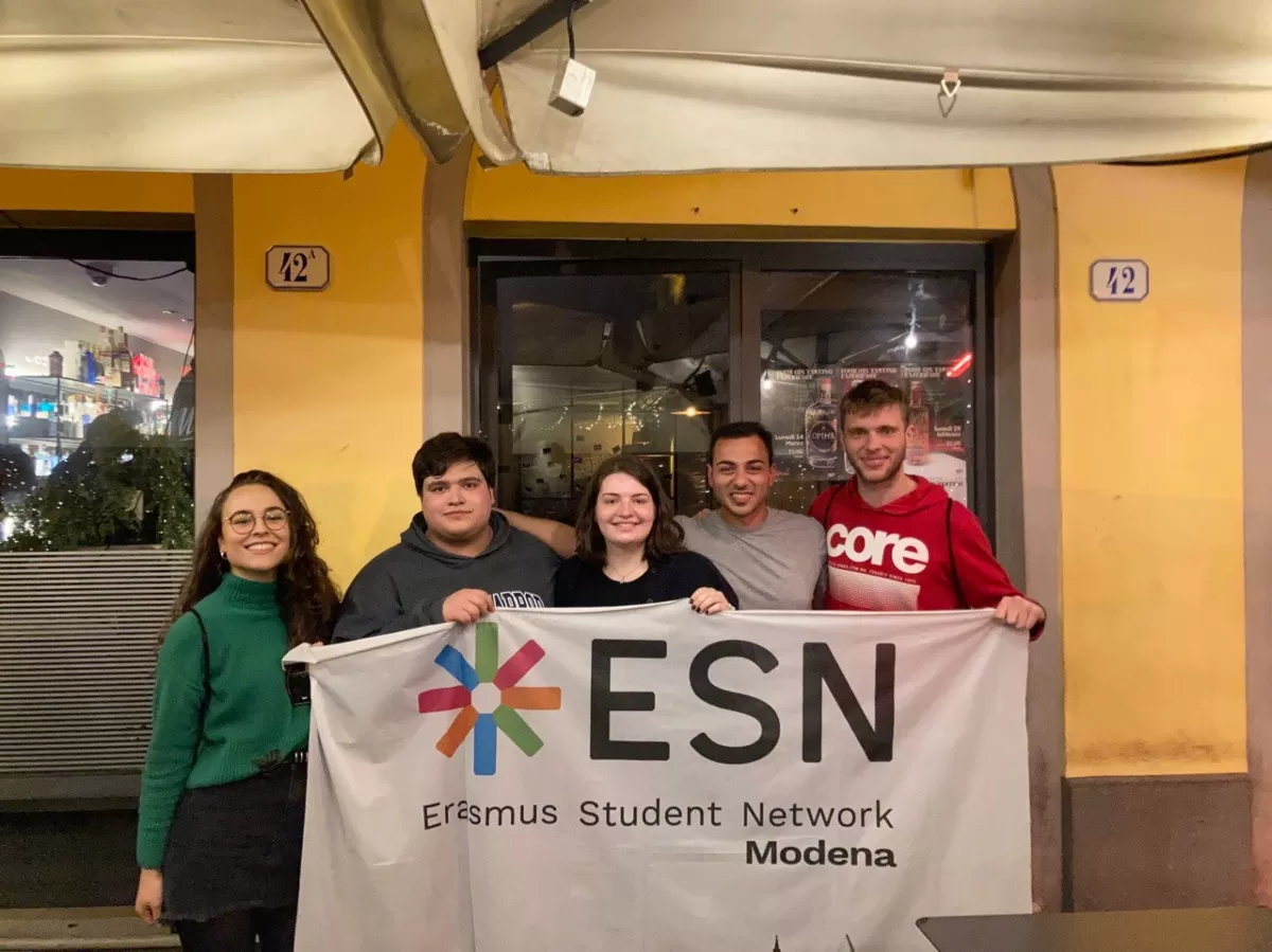 five international students from the winning team posing with the ESN Modena flag