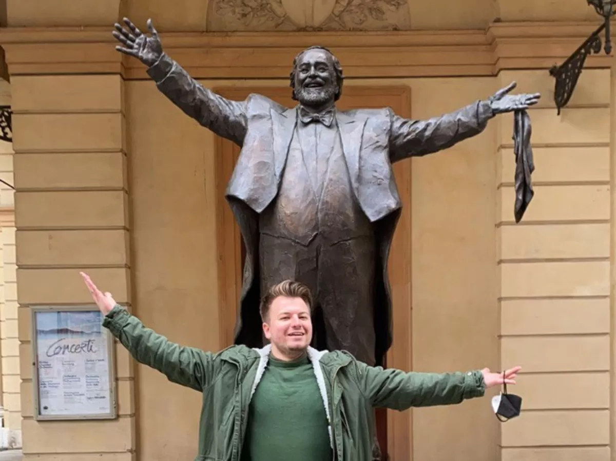 international student posing as Luciano Pavarotti's statue