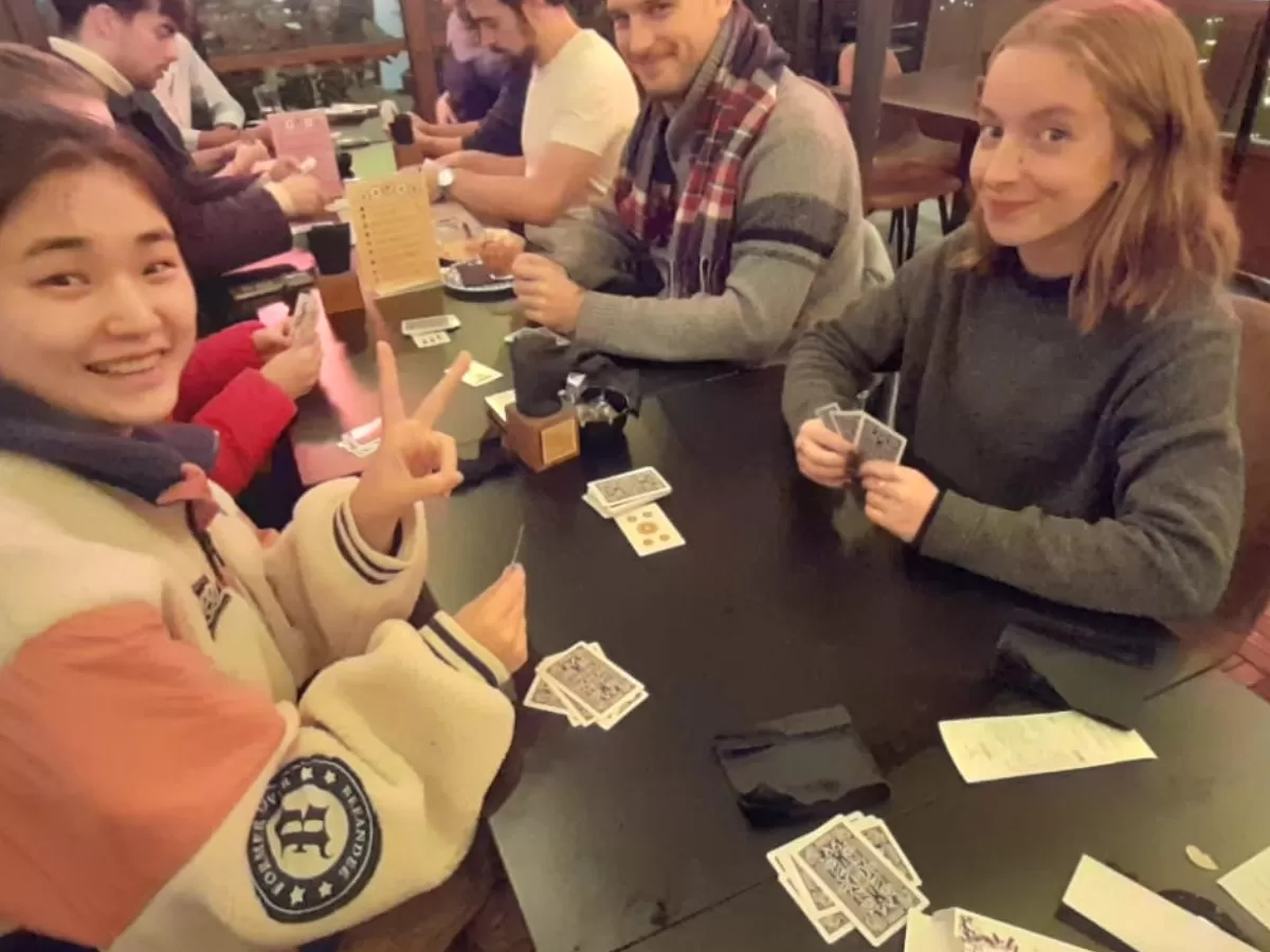 International students that are playing with briscola cards