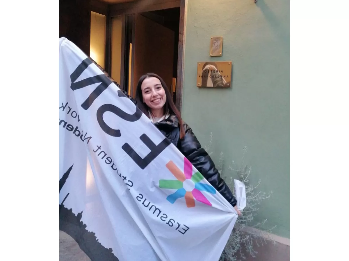 International students with ESN Modena flag in front of one of the location: Osteria francescana