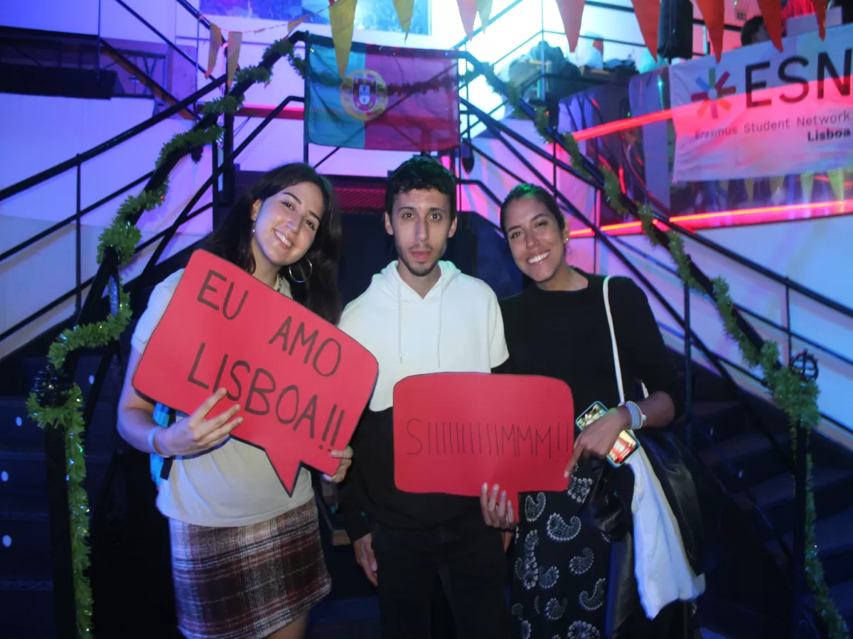 Participants smiling at the camera holding papers with Portuguese sayings