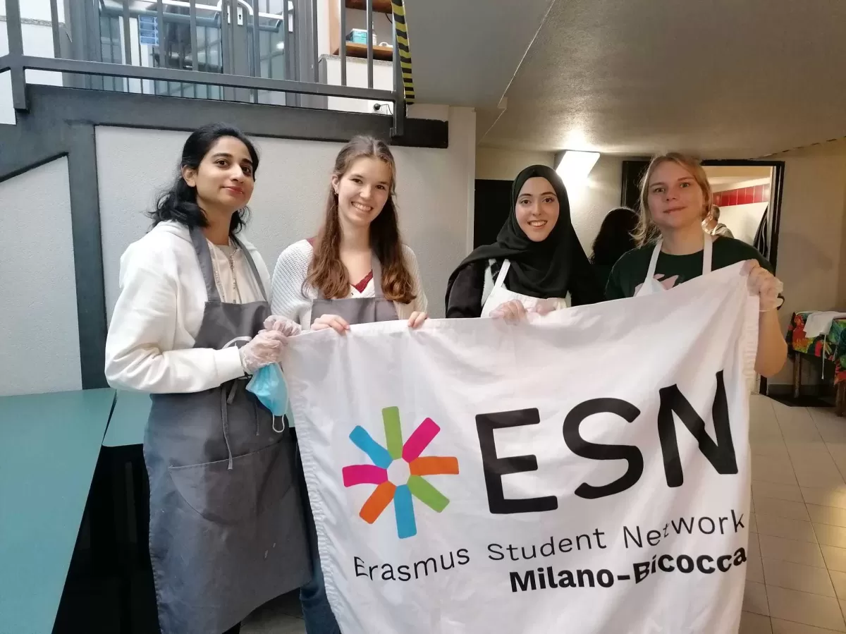 Volunteers posing with the ESN flag wearing their cooking outfit