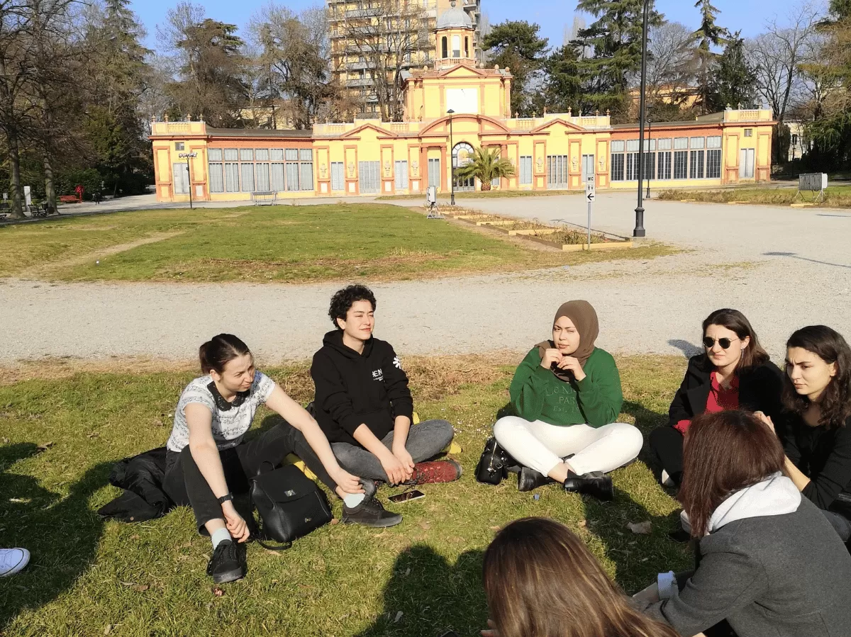 Erasmus students, sitted in giardini Ducali, listening to information about Modena